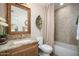 Charming bathroom featuring granite counters, wood cabinets, and decorative mirror and wall art at 18823 N 97Th Ln, Peoria, AZ 85382