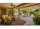 Relaxing covered patio with comfortable seating, ceiling fan, and views of the beautifully landscaped backyard at 18823 N 97Th Ln, Peoria, AZ 85382