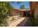 Charming front entrance with a tiled walkway and lush landscaping, leading to a secure door at 18823 N 97Th Ln, Peoria, AZ 85382
