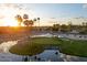 Picturesque golf course at sunset featuring a pond, lush greenery, and serene atmosphere at 18823 N 97Th Ln, Peoria, AZ 85382