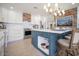 Stylish kitchen featuring a large island with seating, integrated storage, and views into the adjacent living spaces at 18823 N 97Th Ln, Peoria, AZ 85382