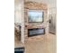 Stylish living space with a stacked wood accent wall, fireplace, and modern appliances at 18823 N 97Th Ln, Peoria, AZ 85382