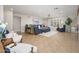 Bright living room featuring a comfortable blue sofa and neutral toned tile flooring at 18823 N 97Th Ln, Peoria, AZ 85382