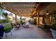 Serene covered patio with stylish furniture, string lights, and well-maintained landscaping at 18823 N 97Th Ln, Peoria, AZ 85382
