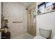 Modern shower with mosaic tile, a glass door, and a built-in shelf at 18823 N 97Th Ln, Peoria, AZ 85382