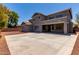 Rear view of a two-story home features a covered patio and spacious paved area, ideal for entertaining at 18868 E Canary Way, Queen Creek, AZ 85142
