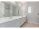 Bright bathroom with double vanity, large mirror and tub shower combo at 18868 E Canary Way, Queen Creek, AZ 85142