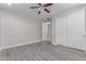 This bedroom features gray wood floors, neutral paint, a ceiling fan, and a closet with sliding doors at 18868 E Canary Way, Queen Creek, AZ 85142