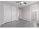 Bedroom featuring ceiling fan, gray wood-look floors, and closet at 18868 E Canary Way, Queen Creek, AZ 85142