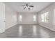 Spacious bedroom with wood-look floors, ceiling fan, and natural light streaming through large windows at 18868 E Canary Way, Queen Creek, AZ 85142
