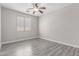 A calming bedroom features gray wood floors, neutral paint, and a window with horizontal blinds at 18868 E Canary Way, Queen Creek, AZ 85142