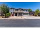 Traditional two-story home boasts a covered porch, gray stucco exterior, and attached two-car garage at 18868 E Canary Way, Queen Creek, AZ 85142