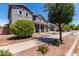 Charming two-story home showcases manicured landscaping, gray stucco, and a welcoming front porch at 18868 E Canary Way, Queen Creek, AZ 85142
