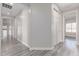 Hallway with gray wood floors connects to several rooms with white doors, offering a cohesive design at 18868 E Canary Way, Queen Creek, AZ 85142