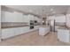 Spacious kitchen featuring white cabinetry, stainless steel appliances, and a large island with tile floors at 18868 E Canary Way, Queen Creek, AZ 85142