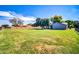 Large backyard with vibrant green grass, mature trees, and partial fence at 20042 W Dunlap Rd, Buckeye, AZ 85326