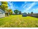 Large backyard with lush lawn and mature trees and a storage shed, offering space for outdoor activities at 20042 W Dunlap Rd, Buckeye, AZ 85326