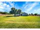 Expansive backyard with green grass, mature trees, and a view of the home at 20042 W Dunlap Rd, Buckeye, AZ 85326
