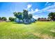 Huge backyard with mature trees, expansive lawn, and view of the house at 20042 W Dunlap Rd, Buckeye, AZ 85326