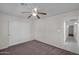 Bedroom with carpet floors, closet, and ceiling fan, leading to a tiled hall at 20042 W Dunlap Rd, Buckeye, AZ 85326