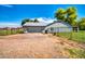 Back exterior view of the home featuring a fenced in yard, gray paint, gravel, garage, and beautiful blue skies at 20042 W Dunlap Rd, Buckeye, AZ 85326