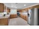 Bright kitchen features stainless steel appliances, wood cabinets, and light countertops, creating a functional cooking space at 20042 W Dunlap Rd, Buckeye, AZ 85326