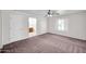 Spacious main bedroom with neutral walls and carpet, ceiling fan, and view into the bathroom at 20042 W Dunlap Rd, Buckeye, AZ 85326