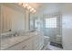 Bathroom with a marble countertop, dual sinks, decorative mirrors, and a glass-enclosed shower at 2218 E Anchor Dr, Gilbert, AZ 85234