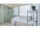 Bathroom featuring a tub, shower, and unique glass block window detail at 2218 E Anchor Dr, Gilbert, AZ 85234