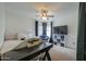 Well-lit bedroom with ceiling fan, TV, cozy chair, and decorative desk at 2218 E Anchor Dr, Gilbert, AZ 85234