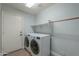 Laundry room featuring modern white appliances, shelving, and an exterior door at 2218 E Anchor Dr, Gilbert, AZ 85234