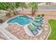 Backyard view of sparkling swimming pool with waterfall feature and patio furniture at 2218 E Anchor Dr, Gilbert, AZ 85234