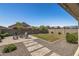 Expansive backyard featuring a patio with seating, a fire pit, and a well-maintained lawn at 22491 E Mewes Rd, Queen Creek, AZ 85142