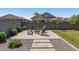 Well-designed backyard with a brick patio, a fire pit, and a beautifully maintained lawn at 22491 E Mewes Rd, Queen Creek, AZ 85142