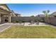 Spacious backyard with a well-maintained lawn, a stylish patio with seating, and attractive landscaping at 22491 E Mewes Rd, Queen Creek, AZ 85142