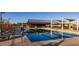 Community lap pool with lounge chairs and shaded picnic tables by the recreation center at 22491 E Mewes Rd, Queen Creek, AZ 85142