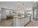 A kitchen featuring a large island and seating, stainless steel appliances, and stylish pendant lighting at 22491 E Mewes Rd, Queen Creek, AZ 85142