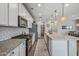 A bright kitchen featuring stainless steel appliances, white cabinets, and a spacious island at 22491 E Mewes Rd, Queen Creek, AZ 85142