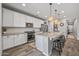 The modern kitchen features an island with bar seating, stainless steel appliances, and ample cabinet space at 22491 E Mewes Rd, Queen Creek, AZ 85142