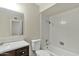 Bright bathroom featuring white tiling, quartz countertop, and dark wood cabinets at 2424 E Fairfield St, Mesa, AZ 85213