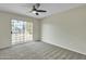 Large bedroom features a sliding glass door, plush carpet, and neutral colored walls at 2424 E Fairfield St, Mesa, AZ 85213