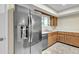 Kitchen features stainless steel refrigerator, modern countertops, and wood cabinets at 2424 E Fairfield St, Mesa, AZ 85213