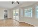 Inviting living room with a sliding glass door, several windows for natural light, and terracotta-tiled flooring at 2424 E Fairfield St, Mesa, AZ 85213