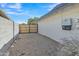 Side yard featuring a gravel ground cover and a wooden gate to the backyard at 2424 E Fairfield St, Mesa, AZ 85213