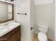 Cozy bathroom with a dark vanity, decorative mirror, and a toilet at 25038 N 40Th Ave, Phoenix, AZ 85083