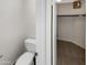 A bathroom toilet next to an open closet with shelves and a clothes hanging bar in a walk in closet at 25038 N 40Th Ave, Phoenix, AZ 85083