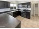 Well-lit kitchen with dark cabinetry, stainless steel appliances, and tile floors at 25038 N 40Th Ave, Phoenix, AZ 85083