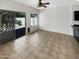 Bright living room featuring neutral tile flooring, backyard access, and a ceiling fan at 25038 N 40Th Ave, Phoenix, AZ 85083