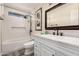 Updated bathroom with a marble vanity, framed mirror, and white tiled shower and tub at 2630 E Dolphin Ave, Mesa, AZ 85204