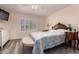 Bedroom features ceiling fan, hardwood floors and comfortable bed with matching side tables at 2630 E Dolphin Ave, Mesa, AZ 85204